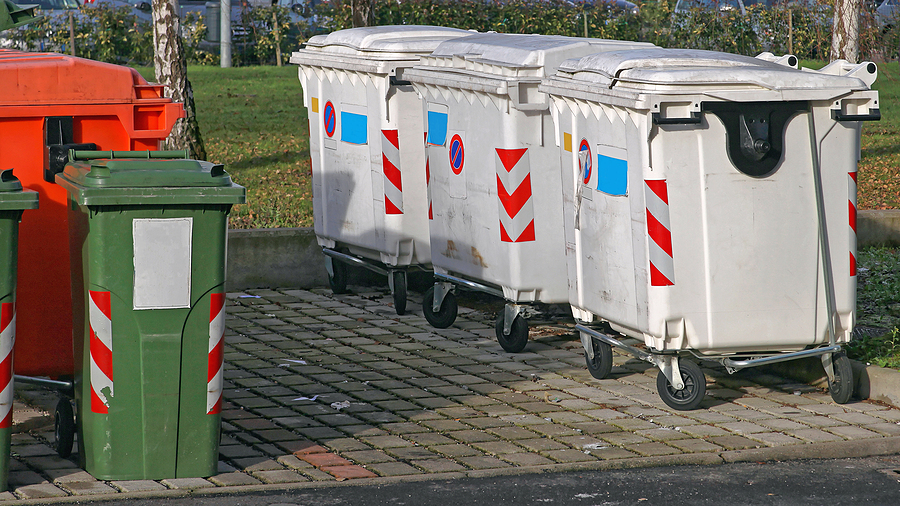 three white garbage containers and different color