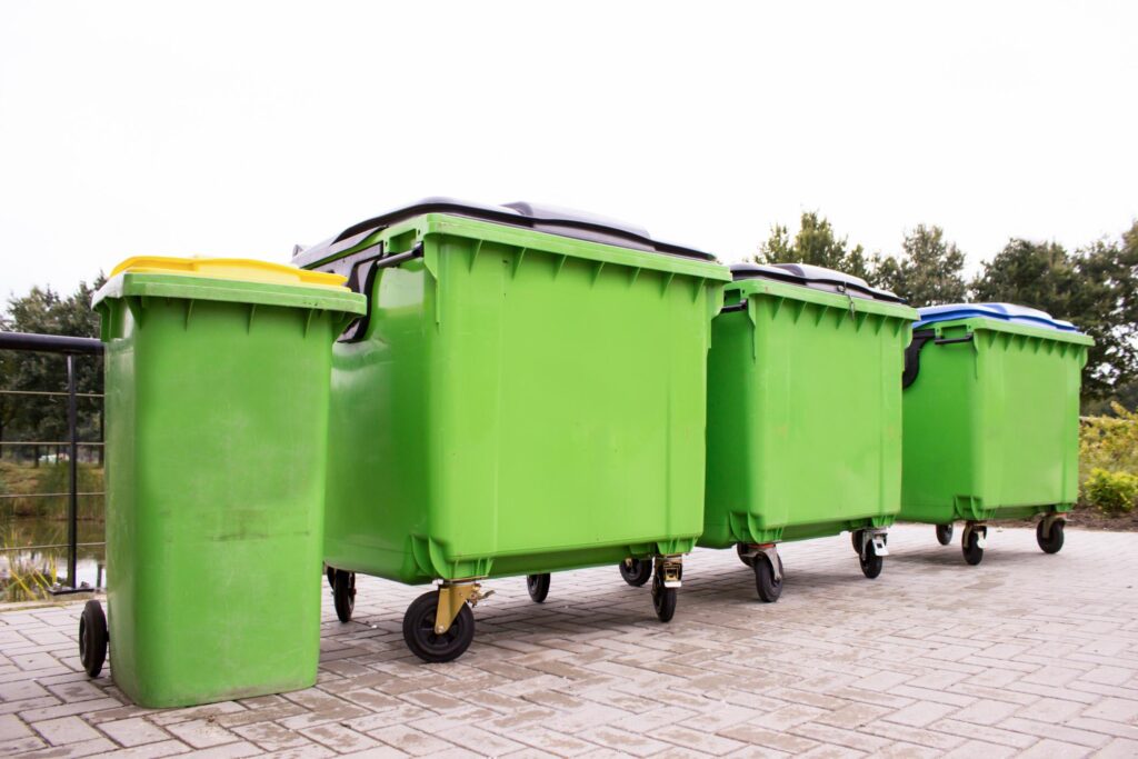 four green garbage containers